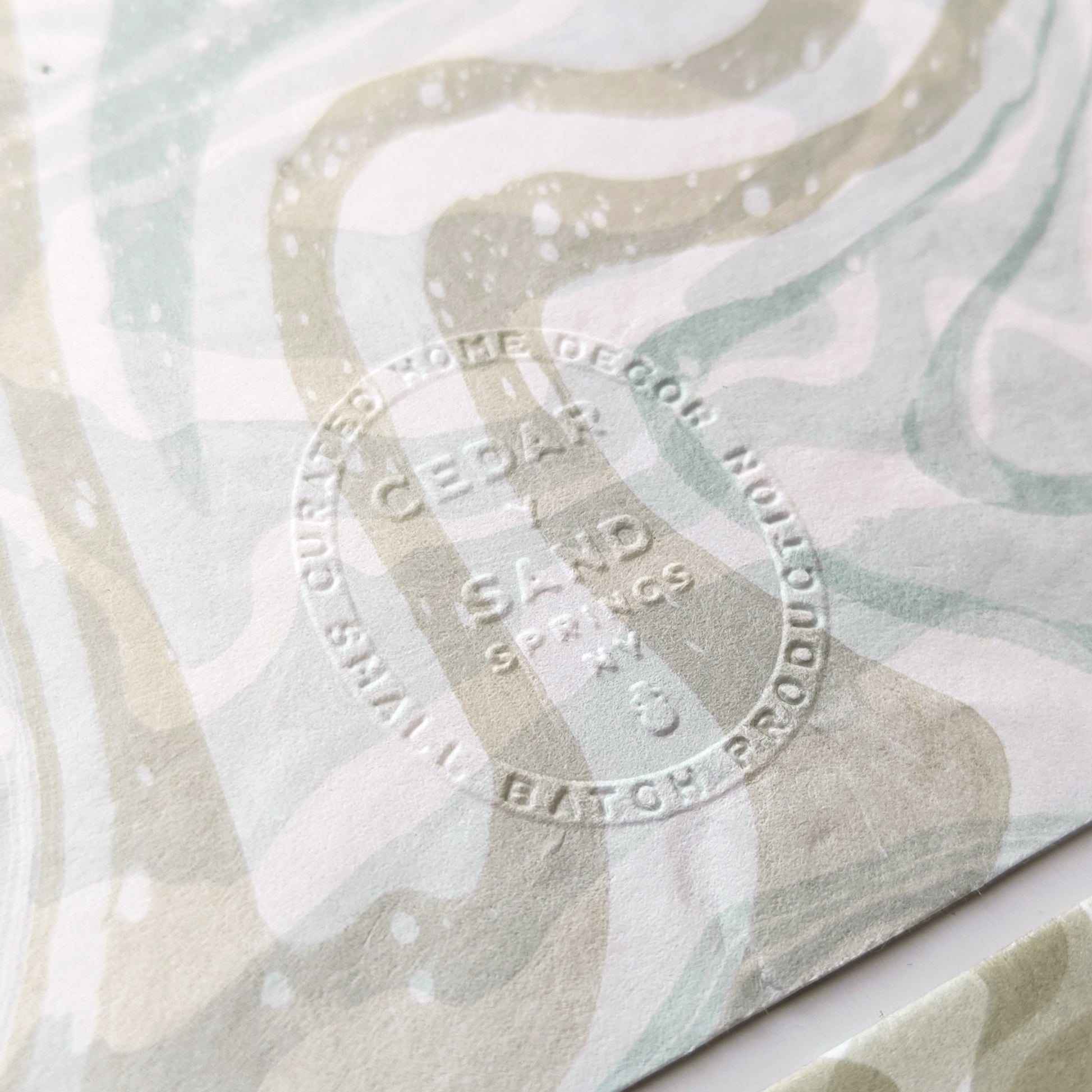 Close-up of Cedar Y Sand embossed insignia on the back of a marbled Hosho notecard.